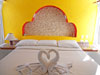 Master bedroom has king-sized bed, ceiling fan and interesting details.