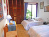 Guest bedroom has two twin beds and garden view.